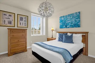 a bedroom with a bed and a chandelier at Luxury 4BR Home at Ventura Golf and Country Club in Orlando