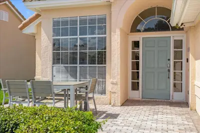 a table and chairs in front of a door at Luxury 4BR Home at Ventura Golf and Country Club in Orlando