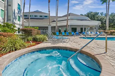a pool at a resort with blue chairs at 5 Minutes to Disney Free Shuttle King & queen bed in Orlando