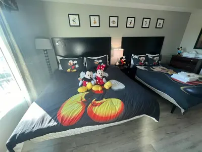 a bedroom with two beds with stuffed animals on them at 5 Minutes to Disney Free Shuttle King & queen bed in Orlando