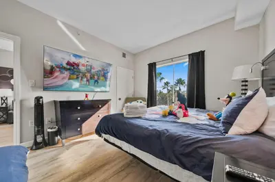 a bedroom with a large bed with children sitting on it at 5 Minutes to Disney Free Shuttle King & queen bed in Orlando