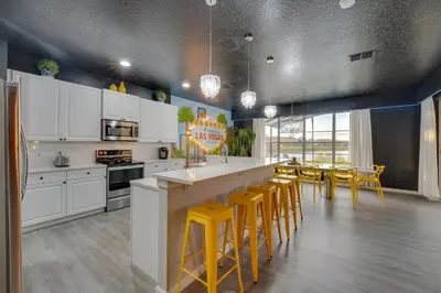 a kitchen with white cabinets and yellow stools at Kissimmee Oasis with Resort Perks! in Kissimmee