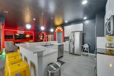 a kitchen with white counters and a red wall at Kissimmee Oasis with Resort Perks! in Kissimmee