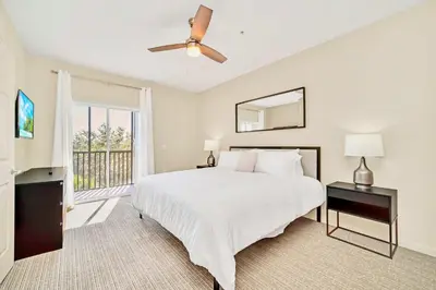 a bedroom with a white bed and a window at 3BR Condo - Near Disney Balcony Pool in Orlando