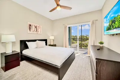 a bedroom with a bed and a window with a balcony at 3BR Condo - Near Disney Balcony Pool in Orlando
