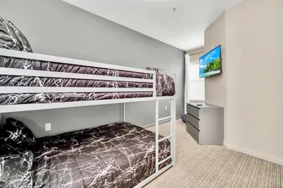 a bedroom with a bunk bed and a flat screen tv at 3BR Condo - Near Disney Balcony Pool in Orlando