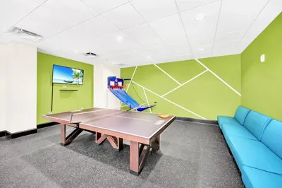 a ping pong table in a room with a blue couch at 3BR Condo - Near Disney Balcony Pool in Orlando