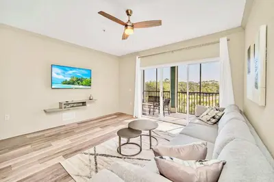 a living room with a couch and a ceiling fan at 3BR Condo - Near Disney Balcony Pool in Orlando