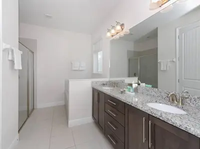 a bathroom with two sinks and a large mirror at Luxurious Villa 9br Encore Resort near to Disney in Orlando