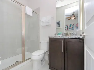 a bathroom with a toilet and a shower and a sink at Luxurious Villa 9br Encore Resort near to Disney in Orlando