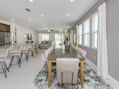 a dining room and living room with a table and chairs at Luxurious Villa 9br Encore Resort near to Disney in Orlando
