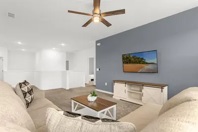 a living room with a couch and a ceiling fan at Upstay Ultimate Orlando Retreat w Pool & Hot Tub Sleeps 16 in Kissimmee