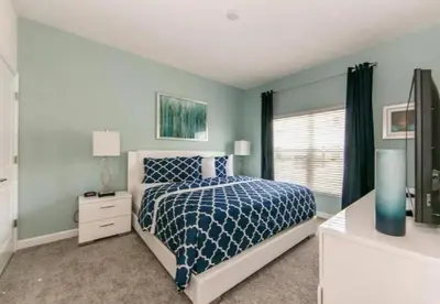a blue bedroom with a bed and a window at Stunning Townhouses 5 Minutes away Disney! in Kissimmee