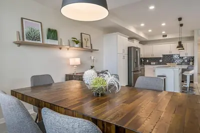 a kitchen and dining room with a wooden table and chairs at Superb Spacious Condo Prime Resort in Kissimmee