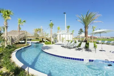a pool with chairs and umbrellas at a resort at Elegant Apartment 3BR2BA • Near Disney • PoolLazy River at Storey Lake Resort SL47318 in Kissimmee