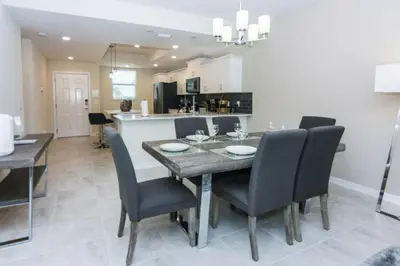 a kitchen and dining room with a table and chairs at Modern Apartment 2BR2BA • Near Disney • Storey Lake Resort SL47314 in Kissimmee