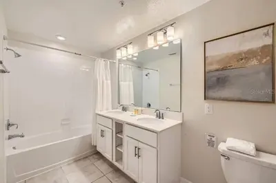 a bathroom with a sink and a tub and a mirror at Luxurious Apartment 2BR2BA • Near Disney • PoolLazy River at Storey Lake Resort SL47315 in Kissimmee