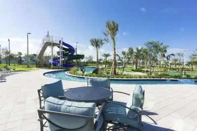 a patio with a table and chairs and a slide at Luxurious Apartment 2BR2BA • Near Disney • PoolLazy River at Storey Lake Resort SL47315 in Kissimmee