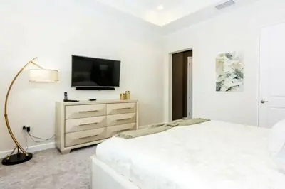 a white bedroom with a bed and a tv at Splendid Apartment 4BR3BA • Near Disney • PoolLazy River at Storey Lake Resort SL47512 in Kissimmee