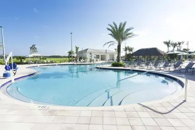 a large swimming pool with chairs in a resort at Splendid Apartment 4BR3BA • Near Disney • PoolLazy River at Storey Lake Resort SL47512 in Kissimmee