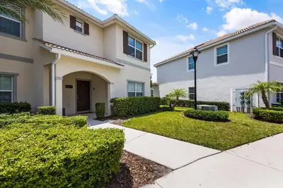 a house with bushes and a sidewalk in front at Premium 5BE4BA Home with Private Pool and Game Room Storey Lake Resort SL4839 in Kissimmee