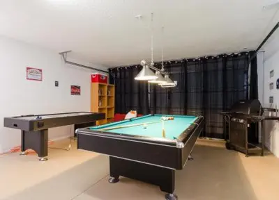 a living room with a pool table and a ping pong table at Emerald Island Kissimmee in Kissimmee