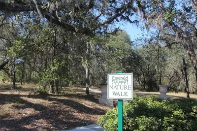 a sign in front of a park with trees at Emerald Island Kissimmee in Kissimmee