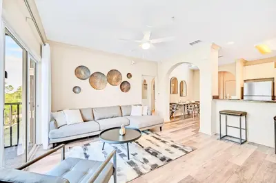 a living room with a couch and a table at Near Disney - 2BR Condo - Balcony Pool in Orlando