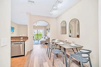 a kitchen and dining room with a table and chairs at Near Disney - 2BR Condo - Balcony Pool in Orlando