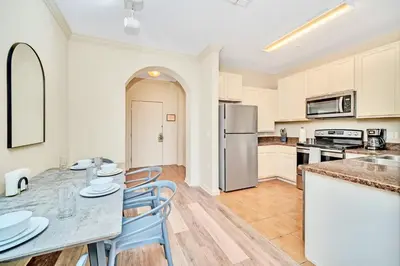 a kitchen and dining room with a table and chairs at Near Disney - 2BR Condo - Balcony Pool in Orlando