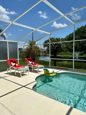 a swimming pool with two chairs and a pool toy at Private pool with a beautiful view overlooking the lake! Near Disney - Universal in Kissimmee