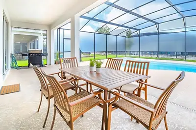 a dining room with a table and chairs and a pool at Family-Friendly Mansion at Sonoma Luxury Resort in Kissimmee