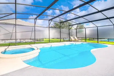 a large swimming pool with a metal structure at Family-Friendly Mansion at Sonoma Luxury Resort in Kissimmee