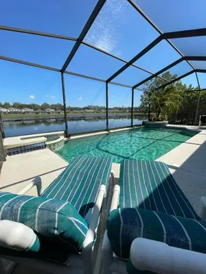 a swimming pool with chairs and water in a building at Its A Dream Family Vacation Rental - Minutes from Disney in Kissimmee