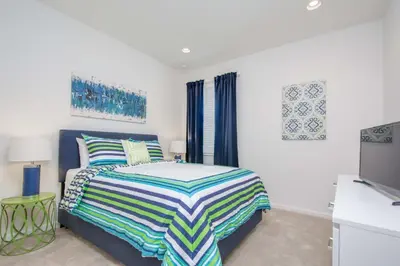 a bedroom with a bed and a flat screen tv at Premium Comfort - Beautiful Home Private Pool in Kissimmee
