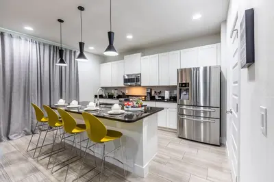 a kitchen with a table and chairs and a refrigerator at Comfy Modern House w Pool Perfect Location in Orlando