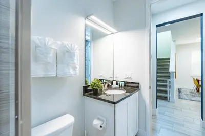 a white bathroom with a sink and a mirror at Comfy Modern House w Pool Perfect Location in Orlando