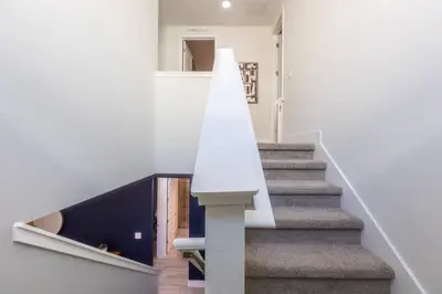 a staircase in a house with a white wall at Comfy Modern House w Pool Perfect Location in Orlando