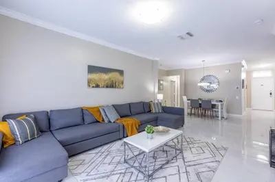 a living room with a blue couch and a table at 4br House w Perfect Location Pool and Much More in Kissimmee
