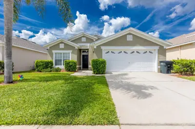 a house with a driveway and a garage at 4br House w Perfect Location Pool and Much More in Kissimmee