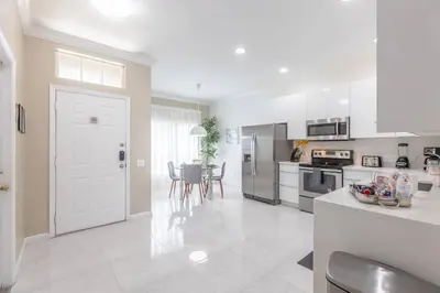 a kitchen with white cabinets and a white door at 4br House w Perfect Location Pool and Much More in Kissimmee