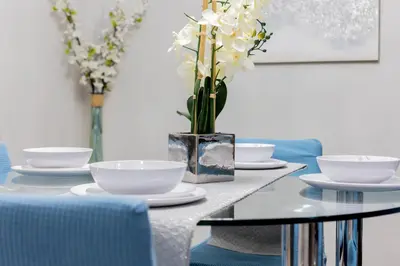 a dining room table with white dishes and a vase of flowers at 3BR Townhouse w Perfect Location in Orlando