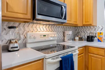 a kitchen with a stove and a microwave at 3BR Townhouse w Perfect Location in Orlando