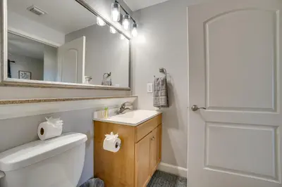 a bathroom with a toilet and a sink and a mirror at 1 Mi to Disney World Lakefront Condo in Orlando! in Orlando