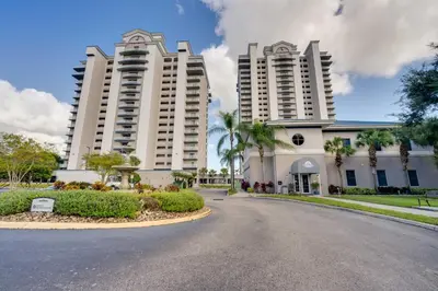 two large white buildings with a street in front at 1 Mi to Disney World Lakefront Condo in Orlando! in Orlando