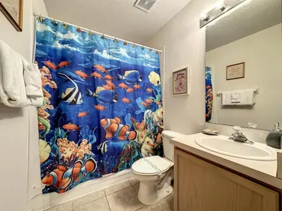 a bathroom with a shower curtain with a fish at Lovely 3 bed Condo Near Disney Quiet Community condo in Kissimmee