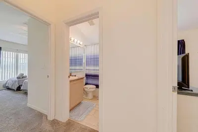 a room with a bathroom with a toilet and a television at 545 -Beautiful 4 Bed Home with Sparkling Pool and Games Room in Orlando