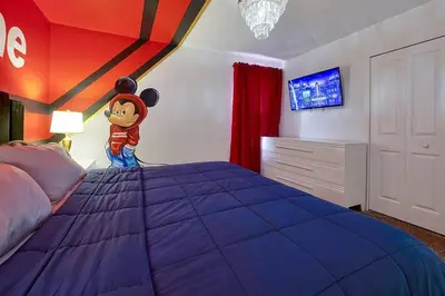 a bedroom with a bed with a mickey mouse on it at NEW Themed 10B VillaPoolSpa in Kissimmee
