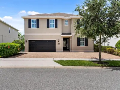 a house with a driveway and a garage at Family Friendly Home With Private Pool, Game Room, Waterpark & Resort Access Near Disney At Encore Resort - 7638Wi in Kissimmee