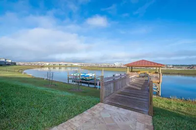 a dock with a gazebo and a boat on a lake at Luxury Villa inside Storey Lake, Kissimmee - No Extra Fees in Kissimmee